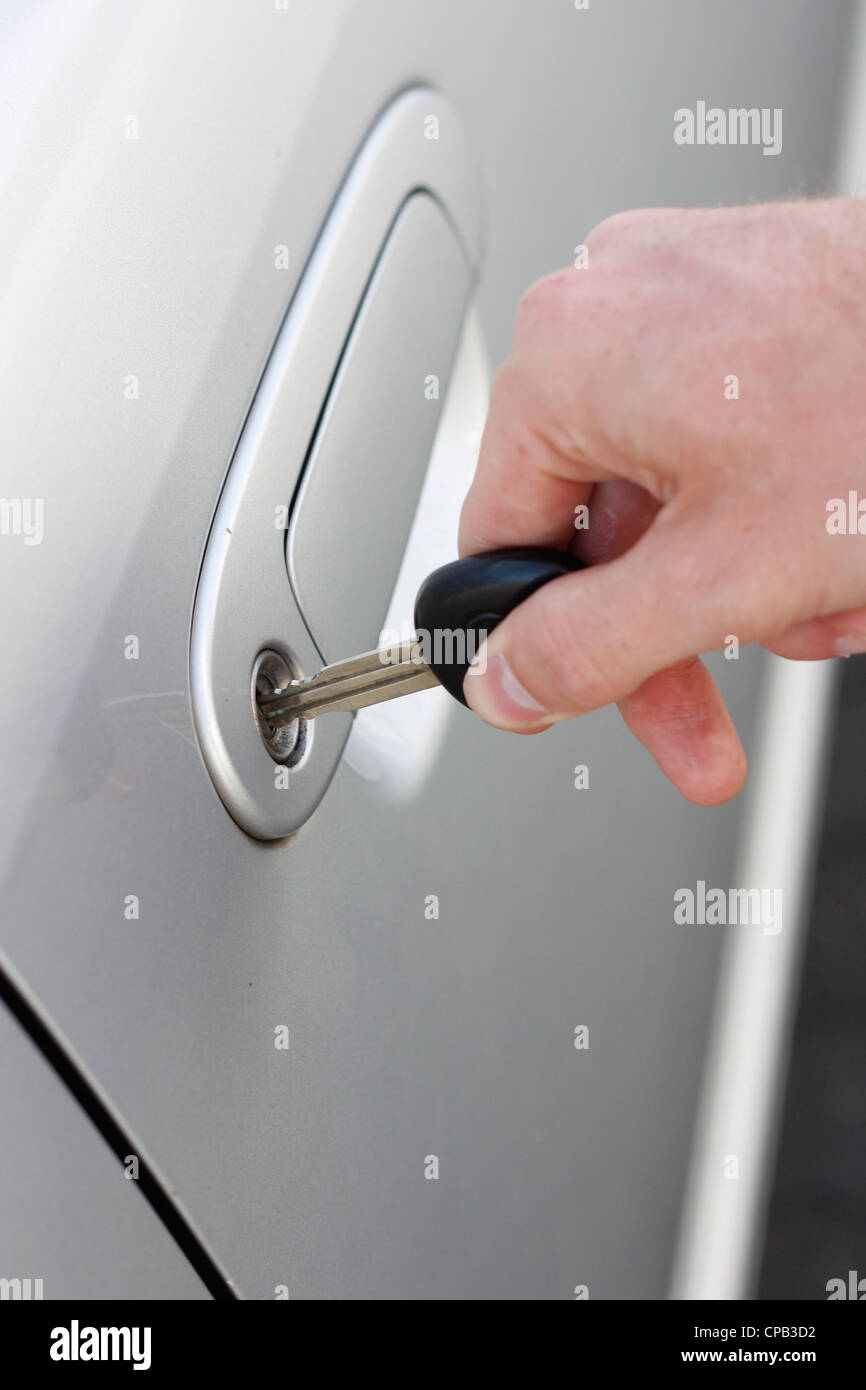 Una mano l'apertura di una portiera di veicolo con chiave Foto Stock