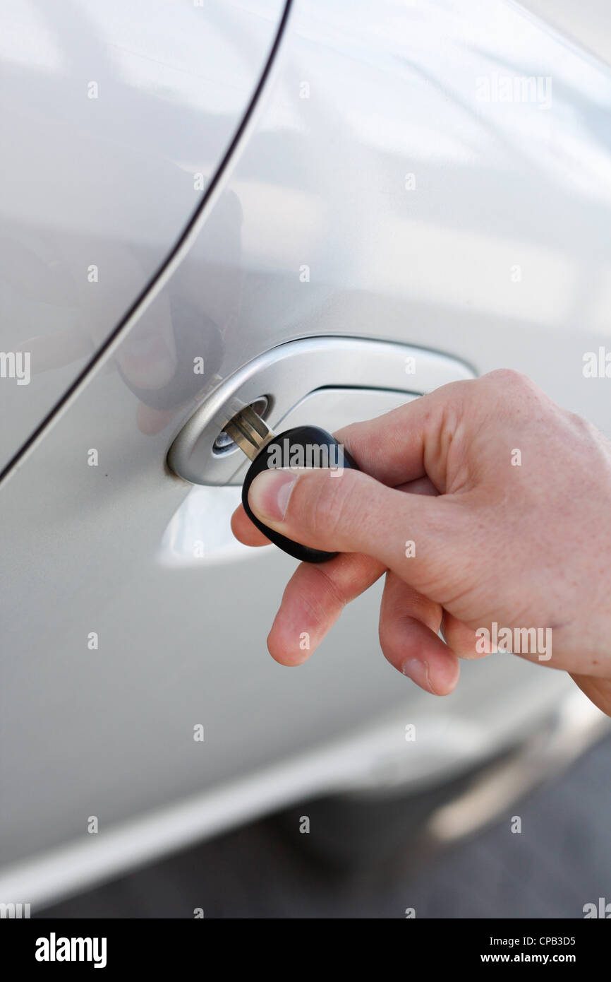 Una mano l'apertura di una portiera di veicolo con chiave Foto Stock