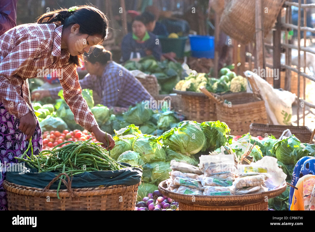 Unidentified donna imposta la pressione di stallo vegetali a Nyaung-U mercato, Myanmar. Foto Stock
