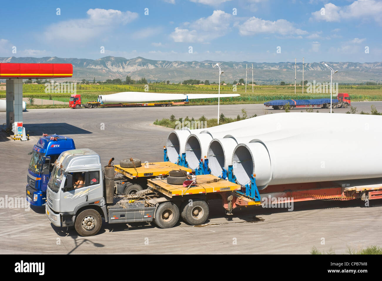 Pale per turbine eoliche su camion per essere trasportati a ovest della Cina dove la maggior parte delle centrali eoliche sono. Foto Stock