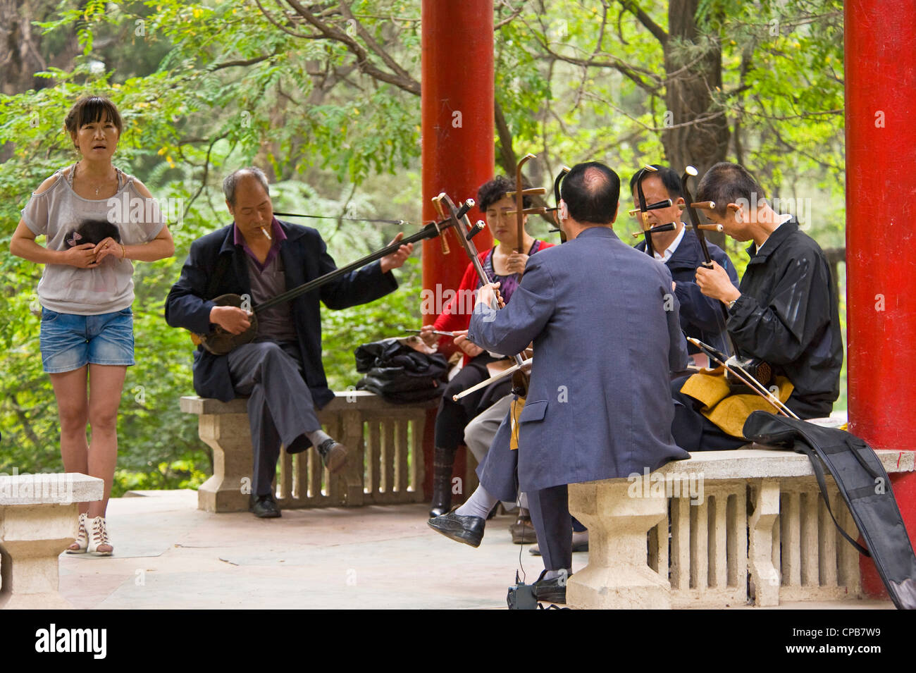 Un gruppo cinese/band di musicisti suonano musica tradizionale cinese (Erhu Cinese - violino principale strumento) la mattina presto a un parco Foto Stock