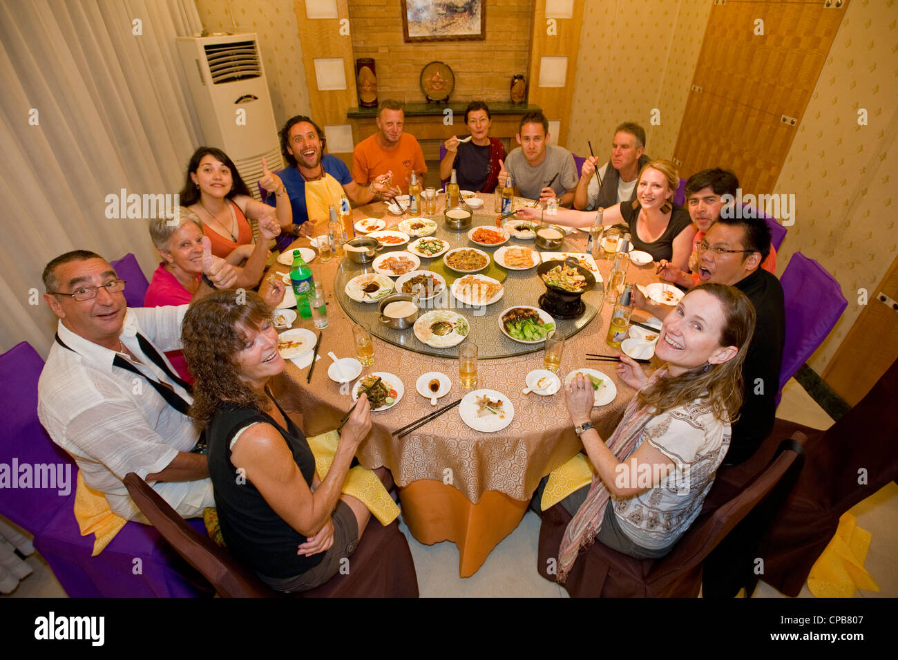 Un gruppo di turisti caucasica godendo di una tradizionale cena Cinese presso un ristorante in Xian. Foto Stock