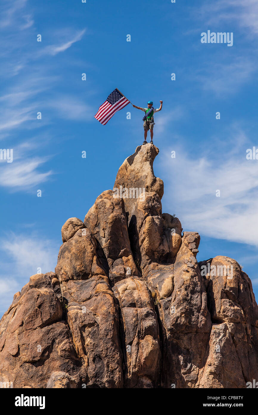 Scalatore sul vertice sventola una bandiera americana. Foto Stock