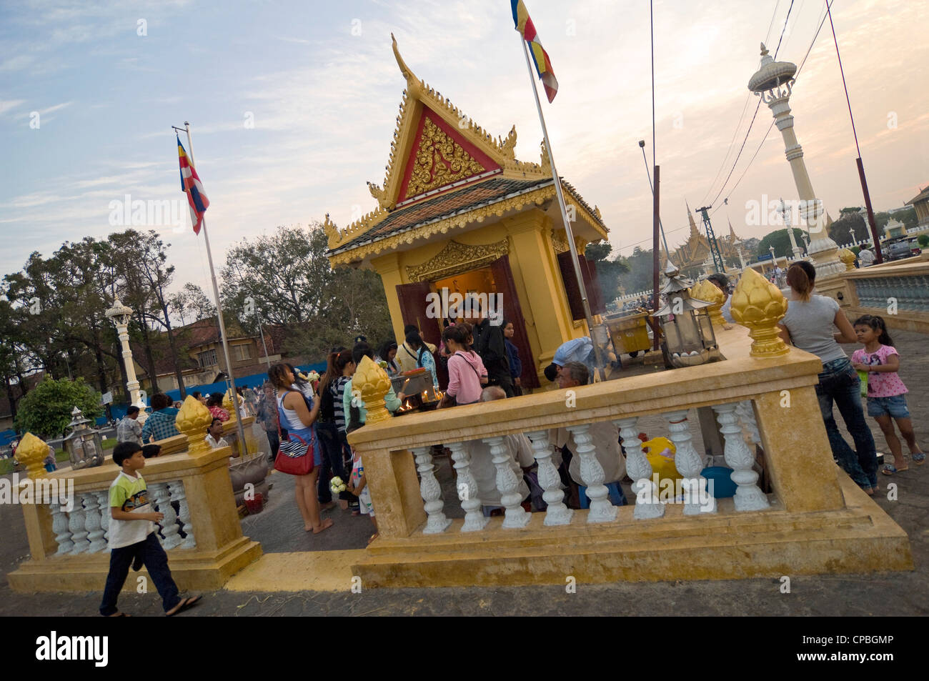 Vista orizzontale di un santuario sul fiume Tonle Sap davanti con molti cambogiani pregando e illuminazione joss-stick. Foto Stock