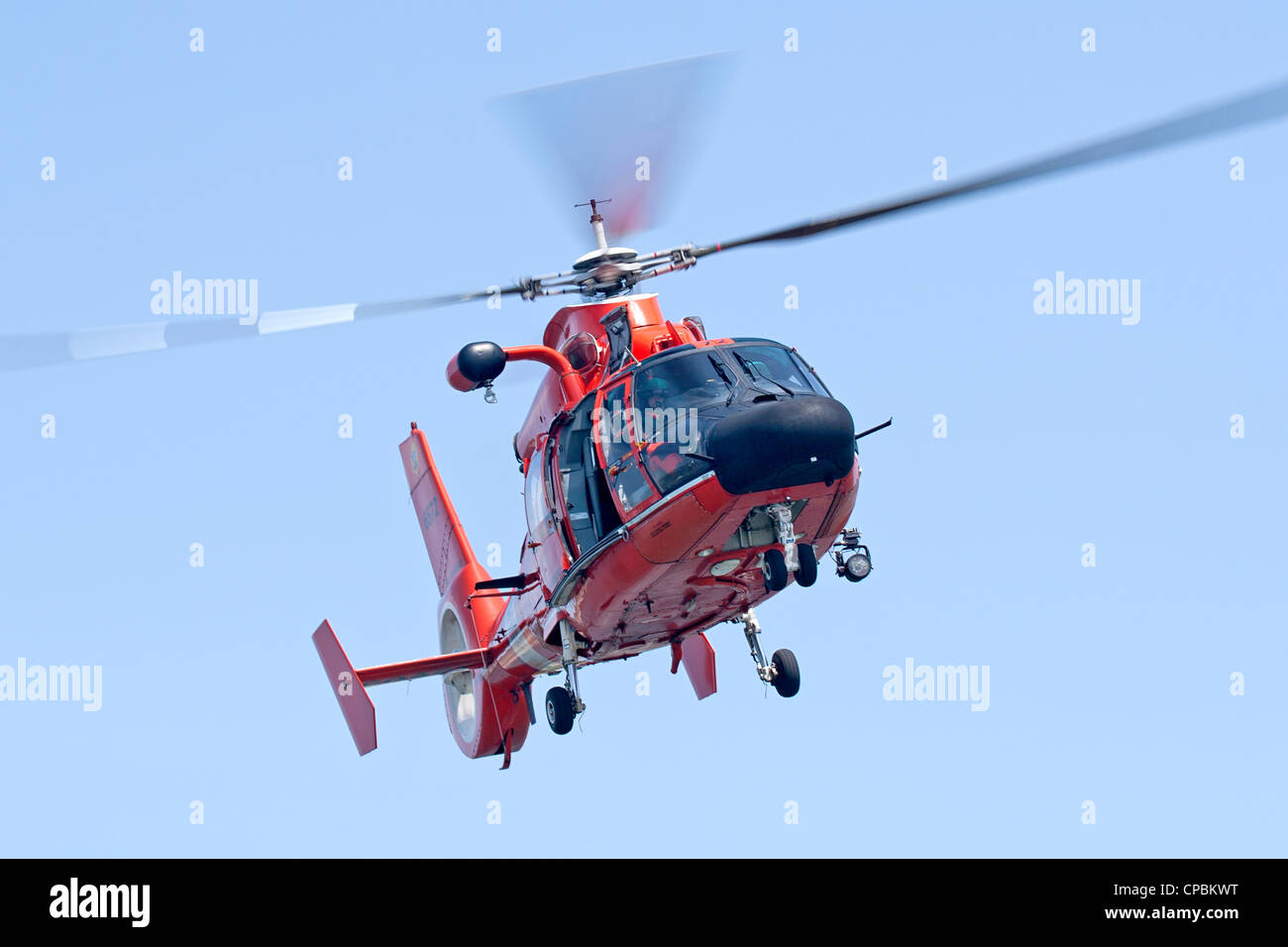 Un United States Coast Guard HH-65C Delfino elicottero avvicinando una guardia costiera recipiente ausiliario. Foto Stock