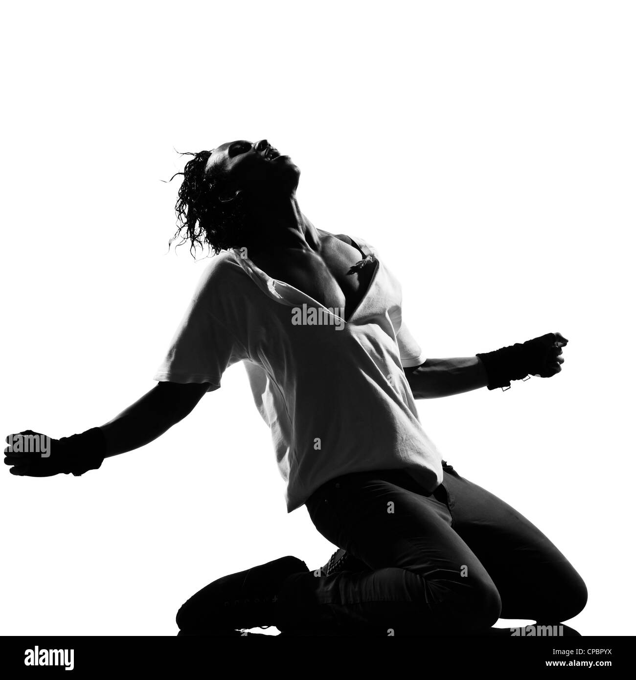 Lunghezza completa silhouette di un giovane ballerino dancing in ginocchio urlando funky hip hop r&b su studio isolato sfondo bianco Foto Stock