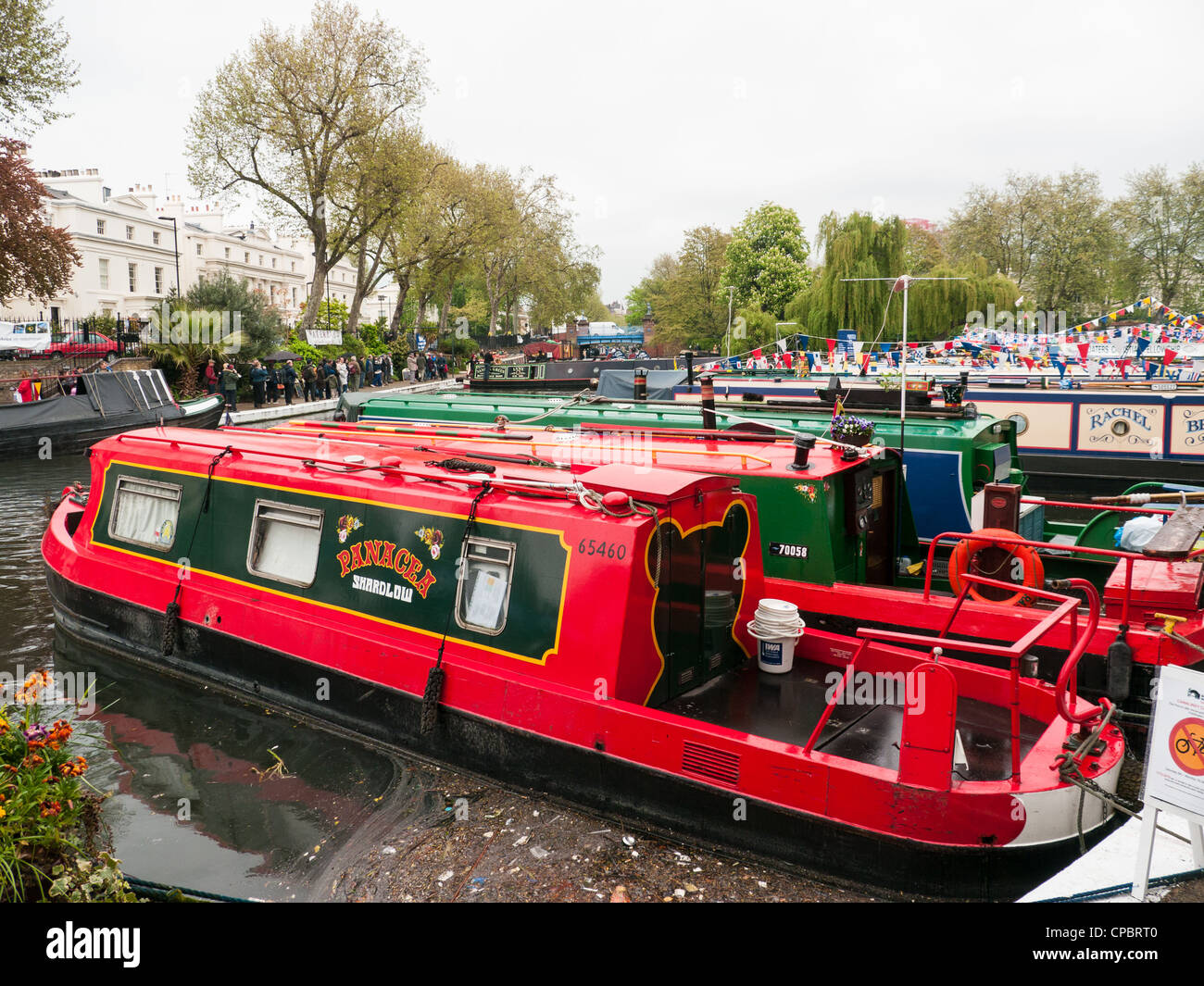 Le file di case galleggianti e imbarcazioni strette sul Grand Union Canal a un Festival di Little Venice, Paddington, West London, Regno Unito Foto Stock