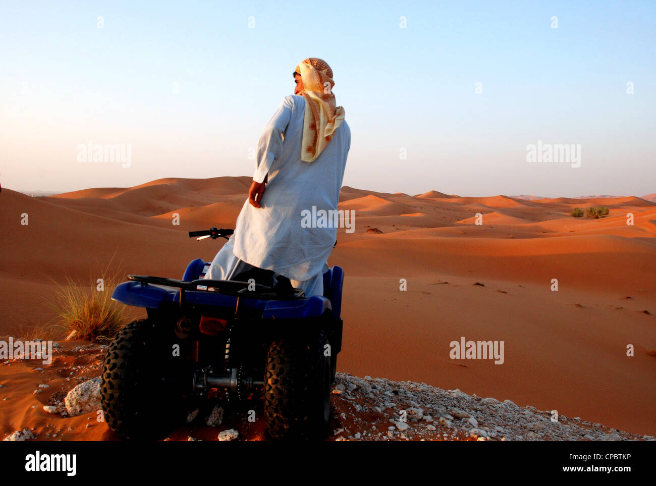 Locale nazionale araba in sella a una moto quad nel deserto di Dubai, UAE Foto Stock