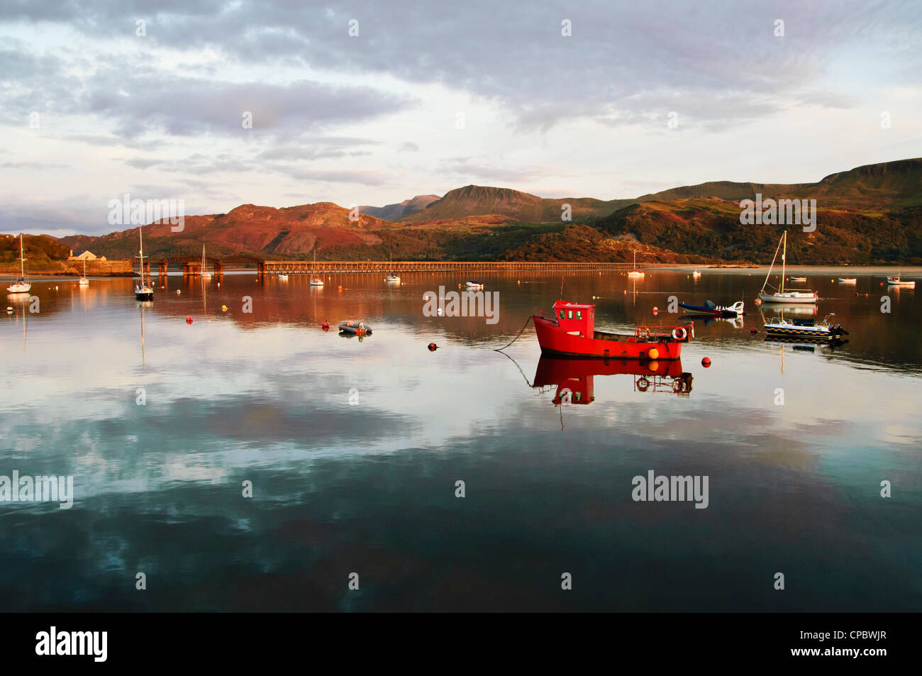 Barche ormeggiate sul Mawddach estuary vicino a Caernarfon con Barmouth Bridge e Cadair Idris dietro il Galles Foto Stock