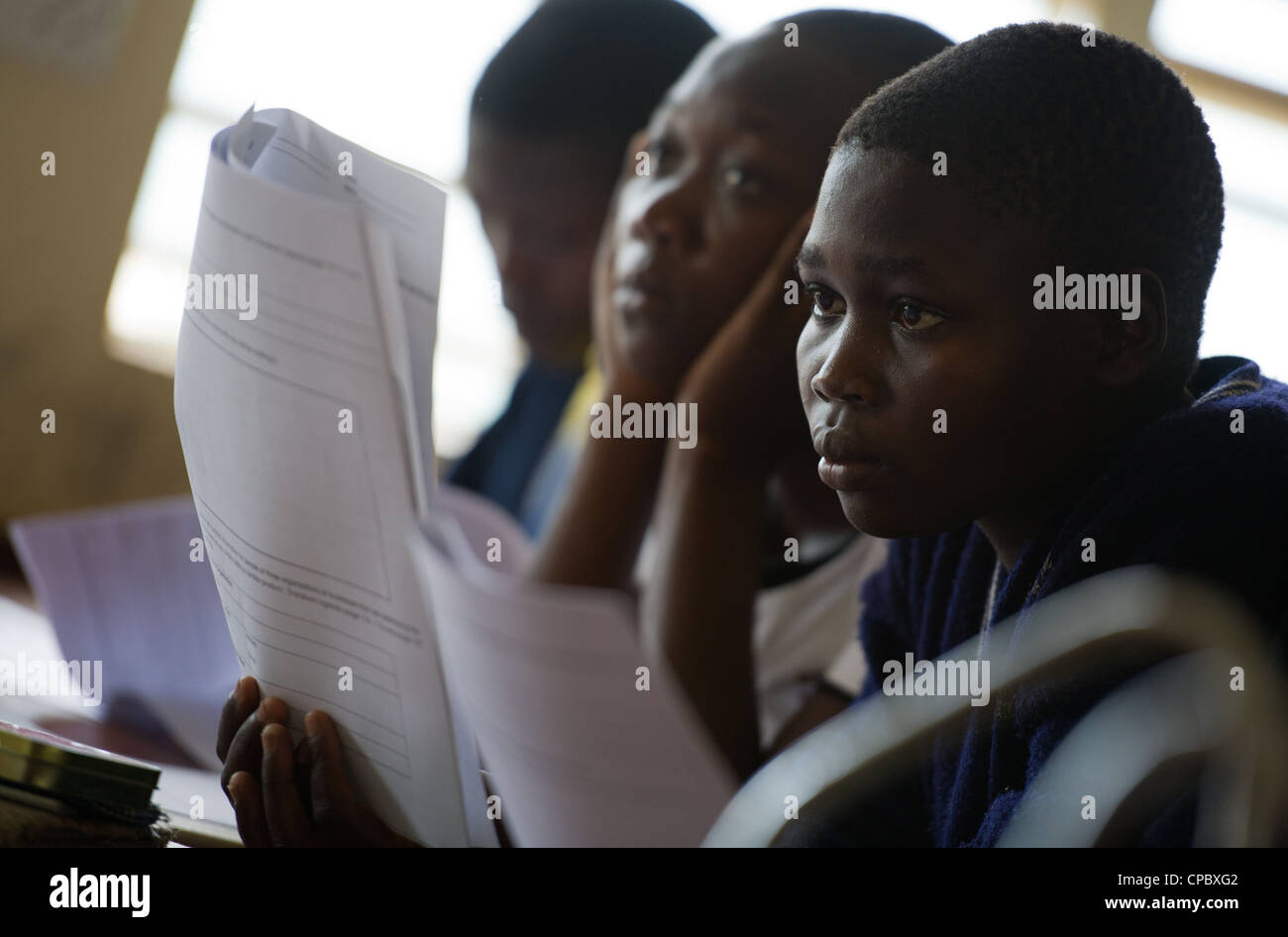 Imprenditorialità i membri del club di ascoltare come loro guida insegna a Budadiri ragazze scuola secondaria in Mbale, Uganda. Foto Stock