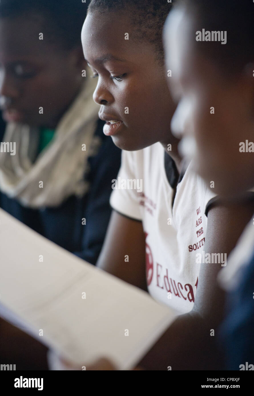 Imprenditorialità i membri del club di ascoltare come loro guida insegna a Budadiri ragazze scuola secondaria in Mbale, Uganda. Foto Stock