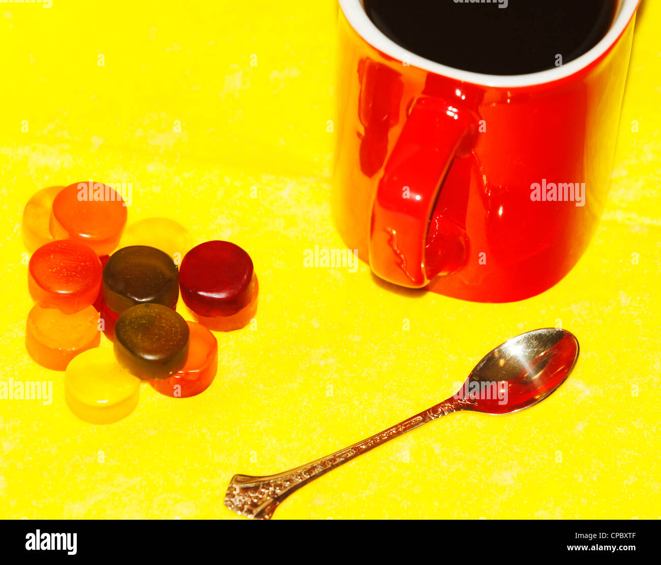 Tazza di caffè nella Red, gustoso, abbastanza dolce, il cucchiaio d'oro su sfondo giallo Foto Stock