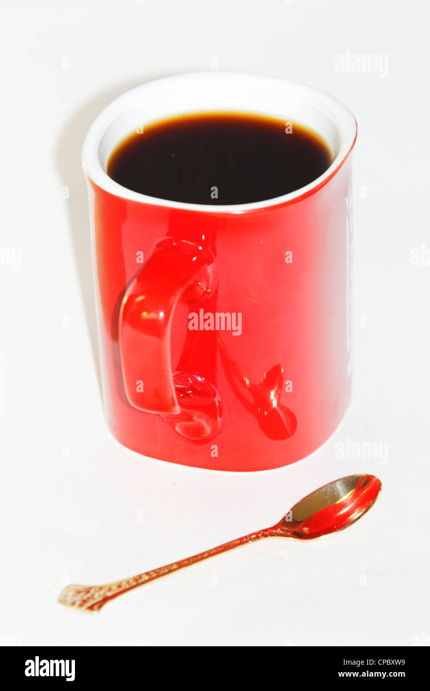 Tazza di caffè nella Red, cucchiaio d'oro su sfondo bianco Foto Stock