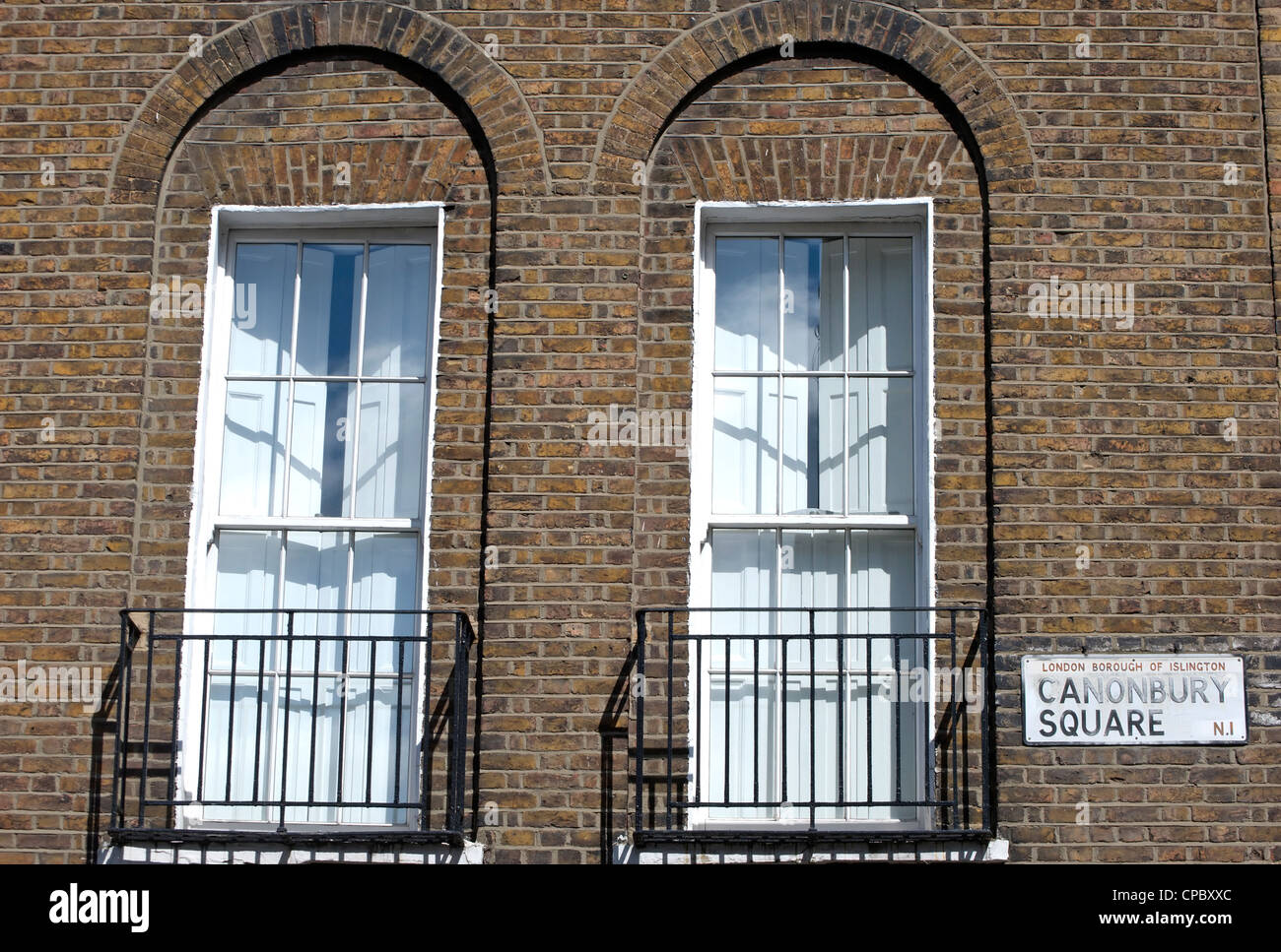 Il nome della strada segno per canonbury square, Islington, Londra, Inghilterra, a fianco di finestre a ghigliottina del XIX secolo la casa Foto Stock