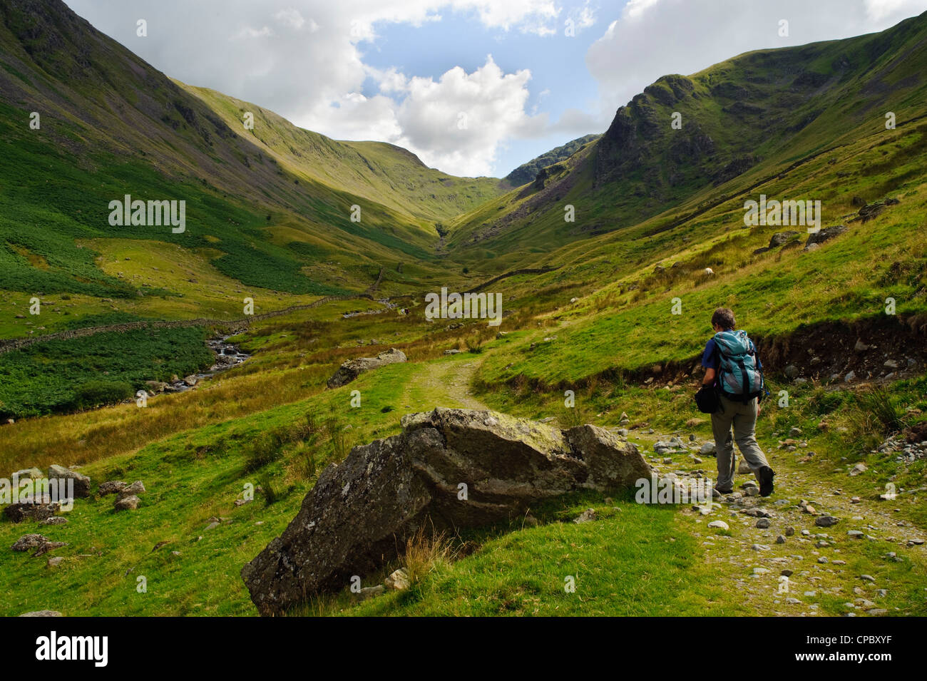 Walker nella valle di pascolo Beck, Hartsop, Patterdale, Lake District Foto Stock