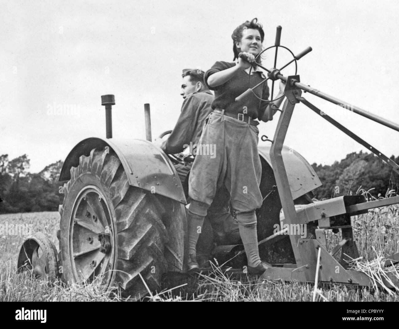 Un esercito di terra ragazza che lavora in una fattoria nel Regno Unito inizio durante la Seconda Guerra Mondiale. Foto Stock