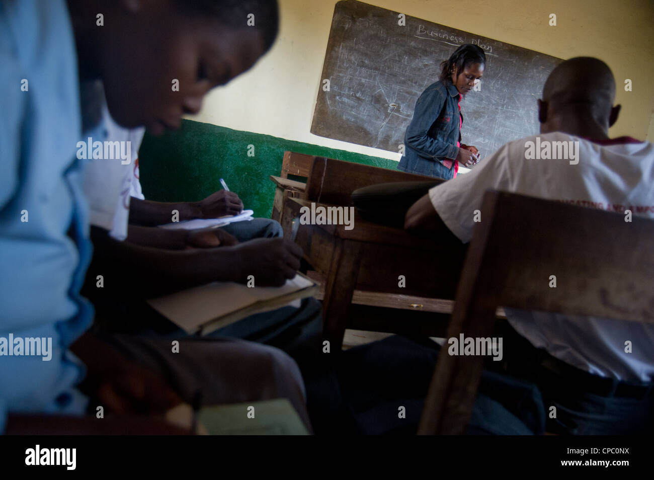 Gli studenti in un club di imprenditorialità prendere appunti mentre la loro guida insegna a Mbale High School di Mbale, Uganda. Foto Stock