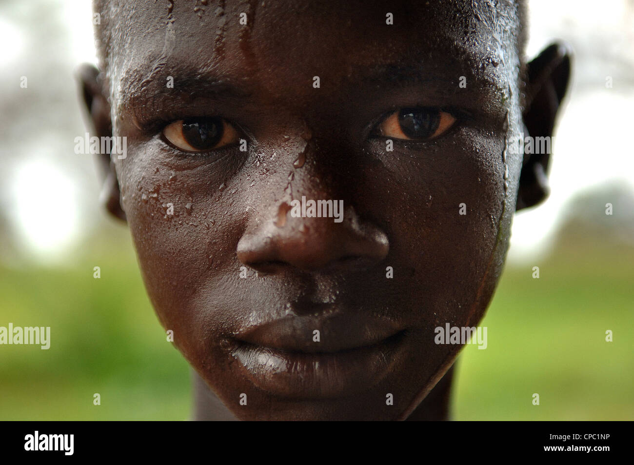 Un ragazzo è catturato in un pomeriggio doccia a pioggia in Lietnhom, Gogrial County, Sud Sudan. Foto Stock