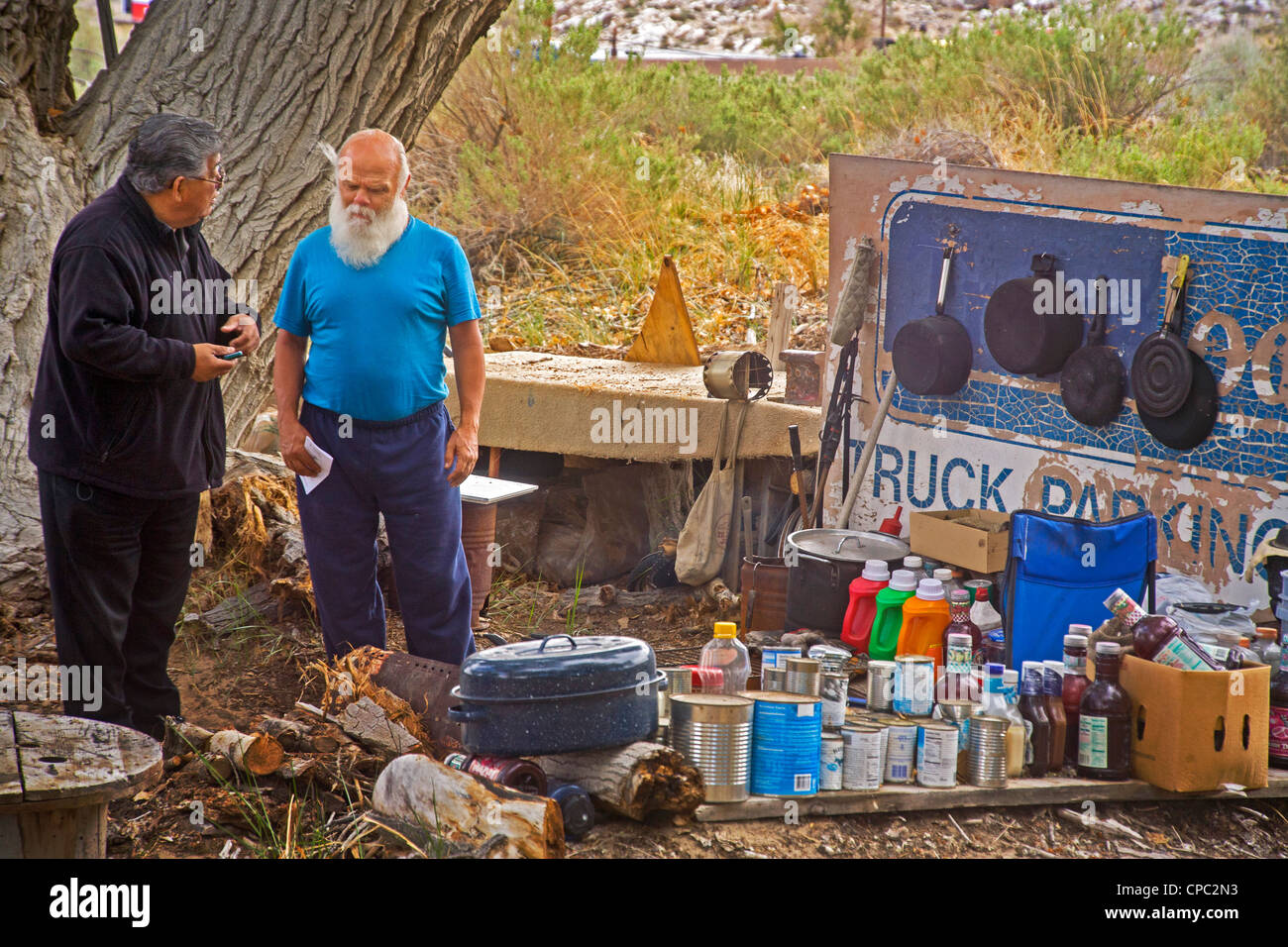 Senzatetto uomo parla a un rappresentante ispanica di una carità locale ad un accampamento all'aperto nel deserto città di Victorville, Foto Stock