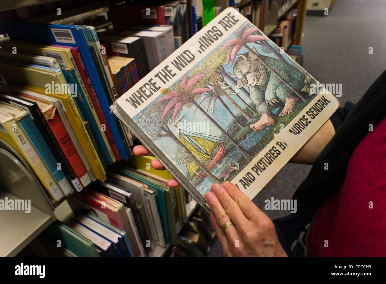 Un lettore esplora un ben indossati copia di maurice sendak il famoso 1963 libro per bambini, "dove le cose selvagge sono' Foto Stock