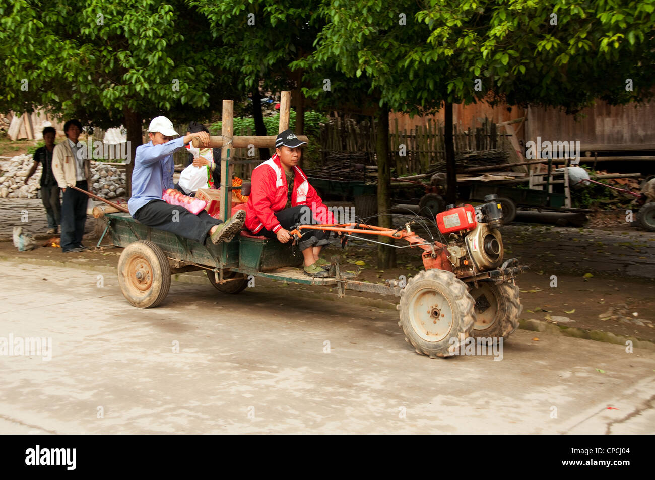 Un piccolo trattore agricolo per le strade di una basha miao (pistola uomini) villaggio, Cina del Sud Foto Stock Un piccolo trattore agricolo per le strade di una basha miao (pistola uomini) villaggio, Cina del Sud Foto Stock