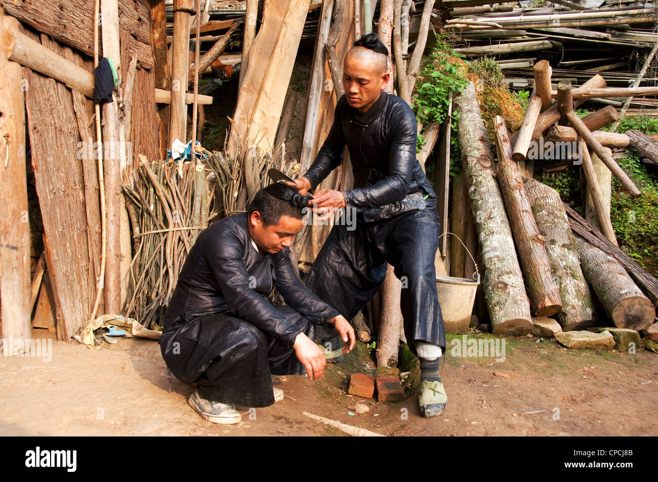Un giovane basha miao (pistola uomini) uomo avente il suo pelo rasato da un falcetto, Cina del Sud Foto Stock Un giovane basha miao (pistola uomini) uomo avente il suo pelo rasato da un falcetto, Cina del Sud Foto Stock