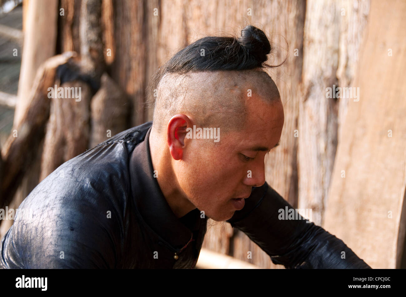 Un giovane basha miao (pistola uomini) uomo la rasatura da un falcetto, Cina del Sud Foto Stock Un giovane basha miao (pistola uomini) uomo la rasatura da un falcetto, Cina del Sud Foto Stock