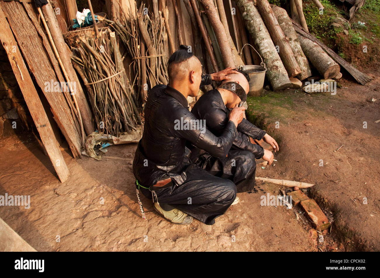 Un giovane basha miao (pistola uomini) uomo avente il suo pelo rasato da un falcetto, Cina del Sud Foto Stock Un giovane basha miao (pistola uomini) uomo avente il suo pelo rasato da un falcetto, Cina del Sud Foto Stock