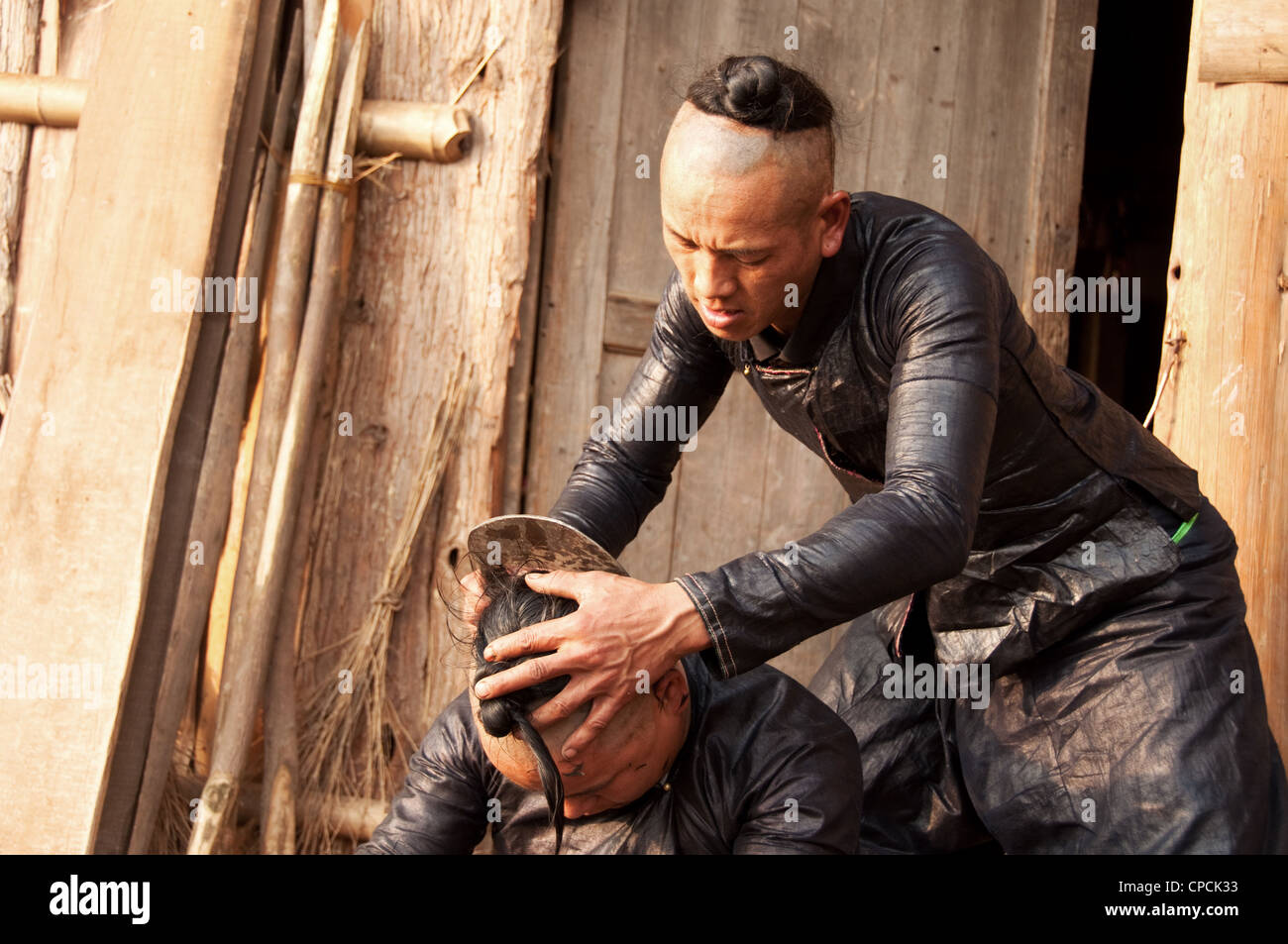 Un giovane basha miao (pistola uomini) uomo avente il suo pelo rasato da un falcetto, Cina del Sud Foto Stock Un giovane basha miao (pistola uomini) uomo avente il suo pelo rasato da un falcetto, Cina del Sud Foto Stock