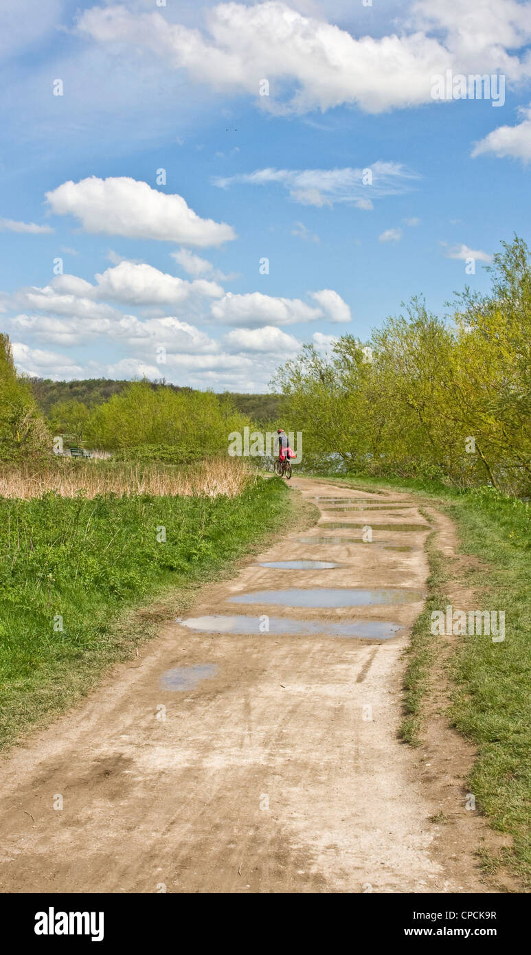 Ciclista a cavallo su una pista sterrata attraverso la campagna inglese Foto Stock