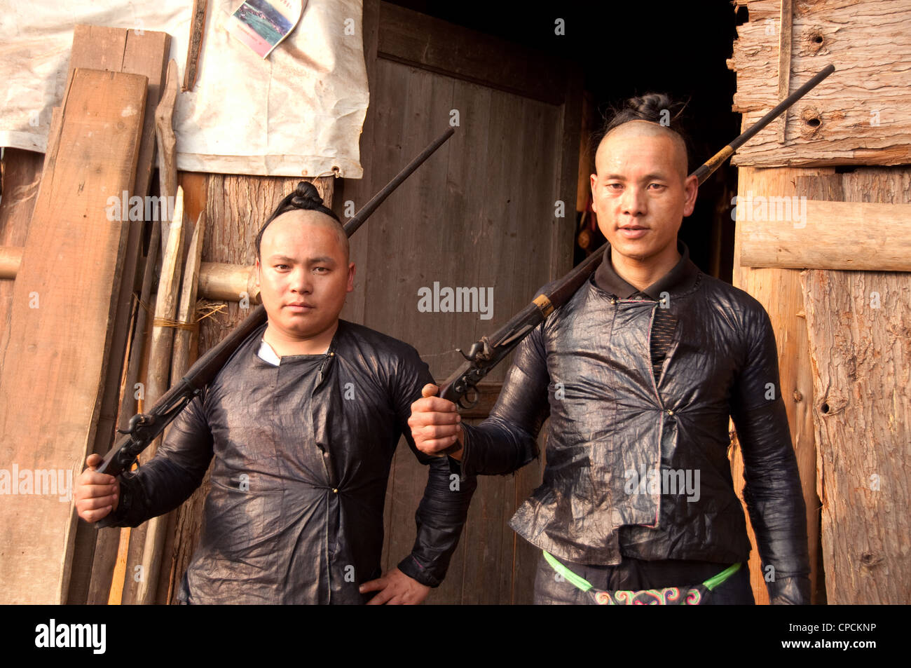 Due giovani basha miao uomini (pistola uomini) con acconciature tradizionali e i loro fucili a canna rigata, Cina del Sud Foto Stock Due giovani basha miao uomini (pistola uomini) con acconciature tradizionali e i loro fucili a canna rigata, Cina del Sud Foto Stock