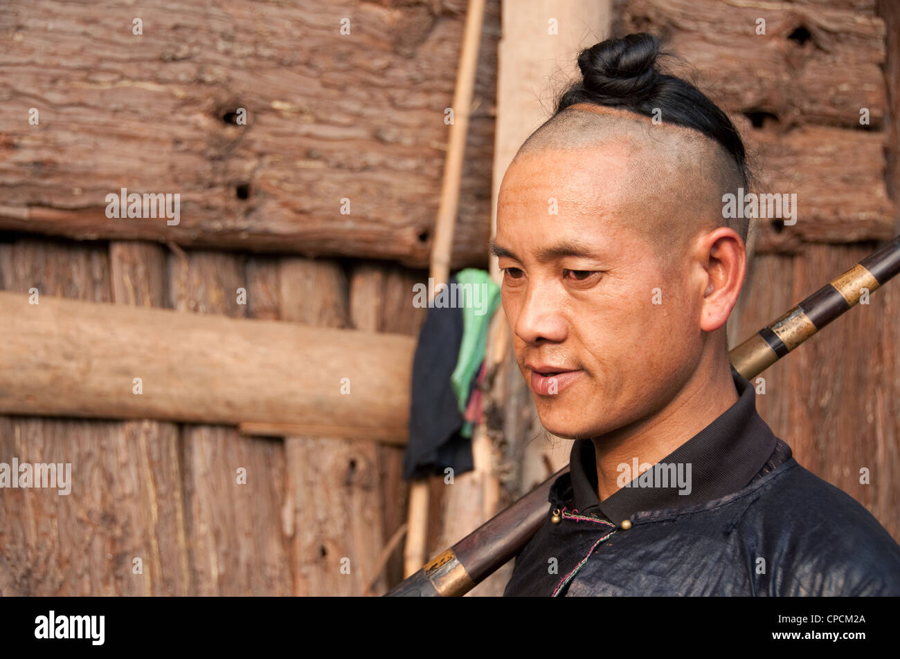 Un giovane basha miao man (pistola uomini) con la tradizionale acconciatura e il suo fucile, Cina del Sud Foto Stock Un giovane basha miao man (pistola uomini) con la tradizionale acconciatura e il suo fucile, Cina del Sud Foto Stock
