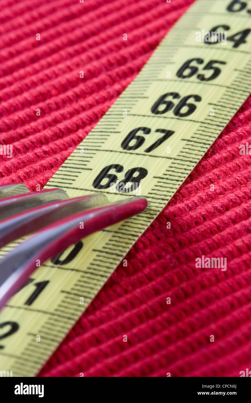 Una forcella e un mesure tape, concettuale perdere peso (soft e messa a fuoco selettiva) Foto Stock