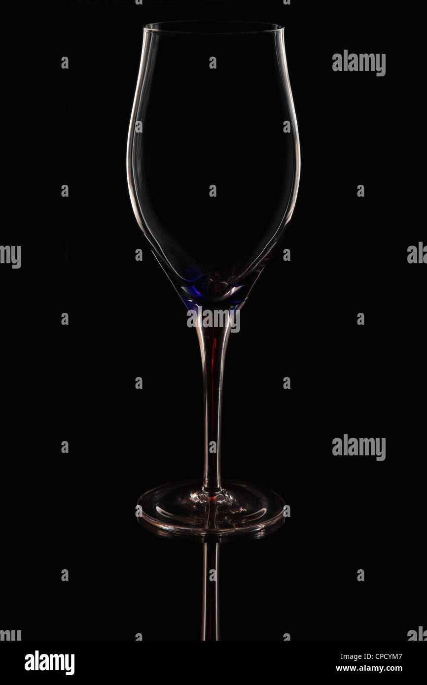 Un bicchiere di vino con un colorato di rosso e blu colpo di stelo contro uno sfondo nero Foto Stock