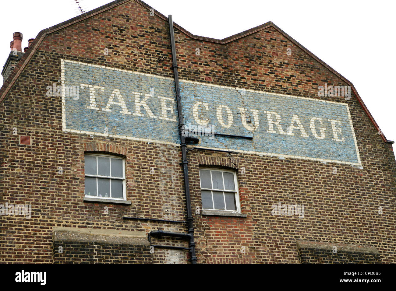 Dipinto 'prendere coraggio' birra pubblicità sul lato dell'edificio, London, Regno Unito Foto Stock