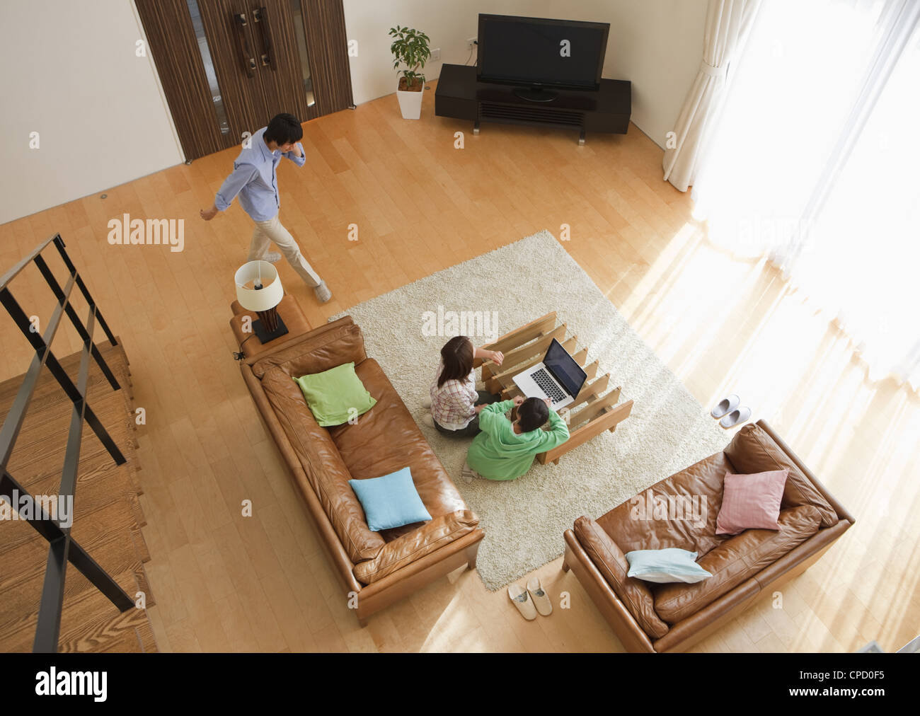 Famiglia guardando il computer portatile in una stanza vivente Foto Stock