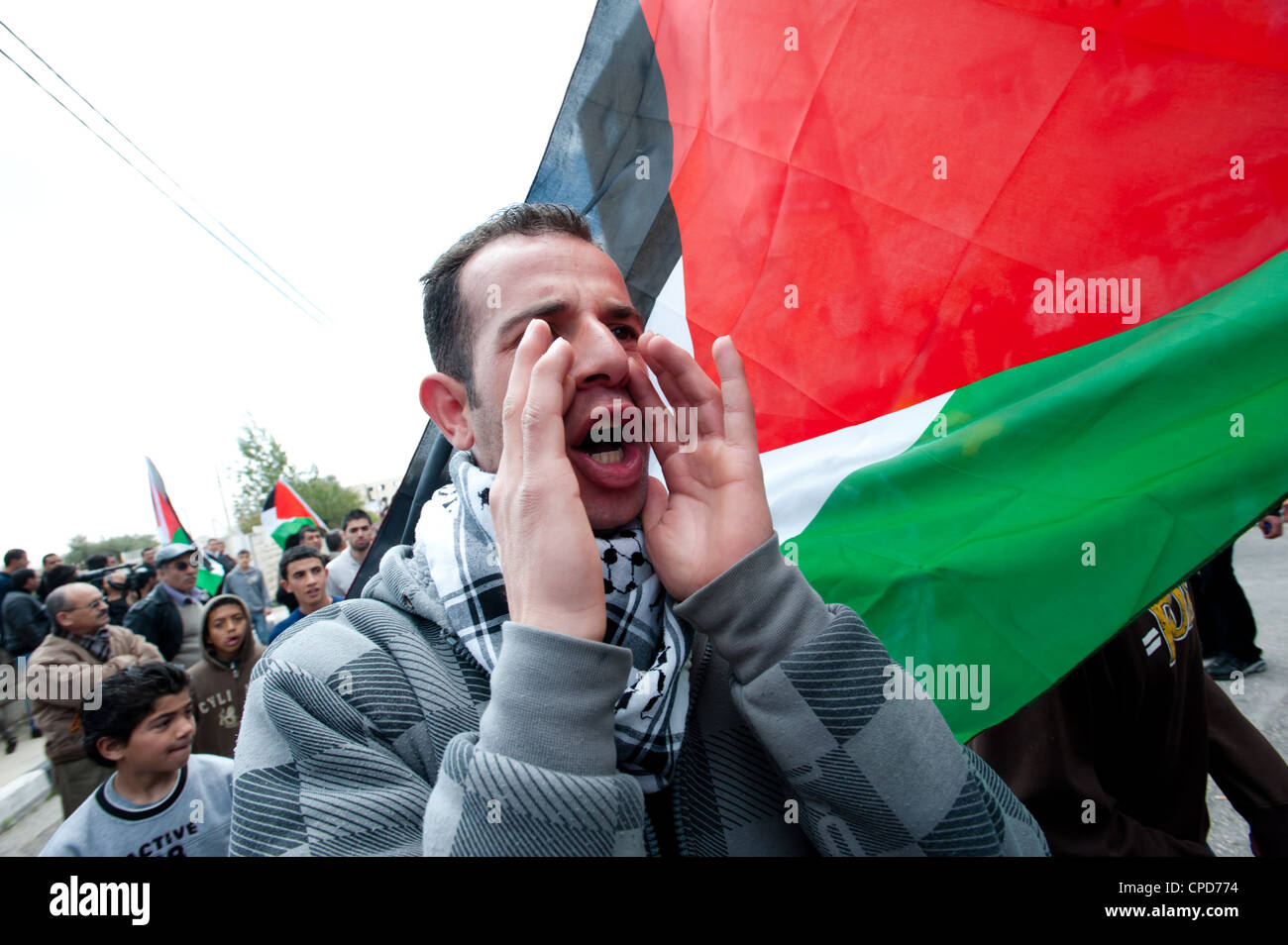 Palestinesi portano bandiere mentre marciando verso il checkpoint di Betlemme terra durante il giorno le proteste. Foto Stock