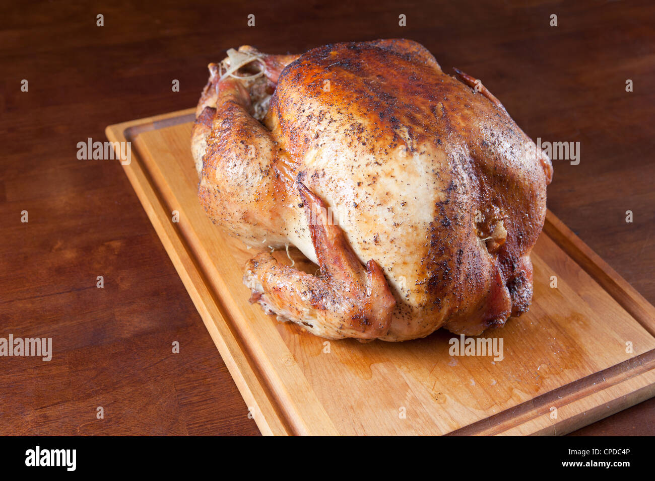 Arrosto di tacchino intero sul tagliere di legno. Foto Stock