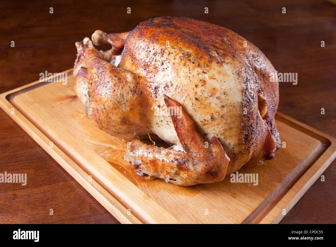 Arrosto di tacchino intero sul tagliere di legno. Foto Stock