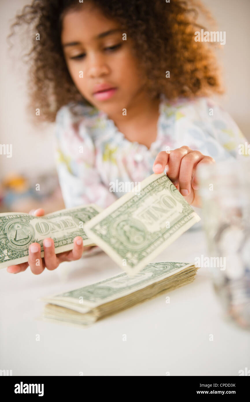 Razza mista ragazza contando le fatture del dollaro Foto Stock