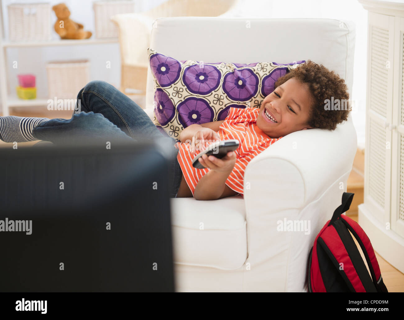 Black Boy posa in poltrona a guardare la televisione Foto Stock