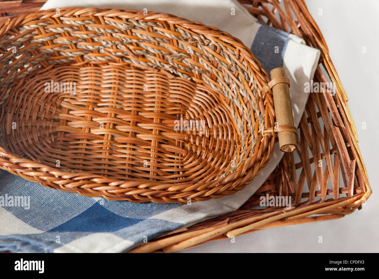 Brown cesto in vimini con un blu panno gingham per la tabella degli appuntamenti Foto Stock