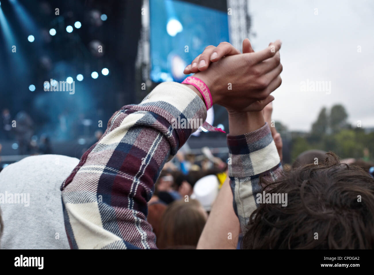 Battendo le mani a un festival di musica con lo stadio in background Foto Stock