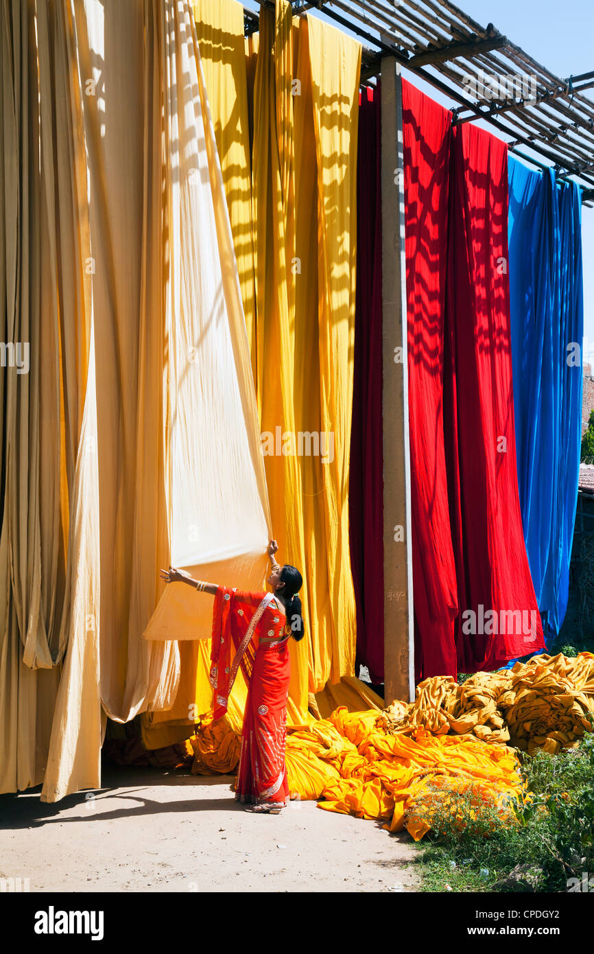 Donna in sari per controllare la qualità di fresco tessuto tinto appesi ad asciugare, Sari fabbrica di indumento, Rajasthan, India, Asia Foto Stock