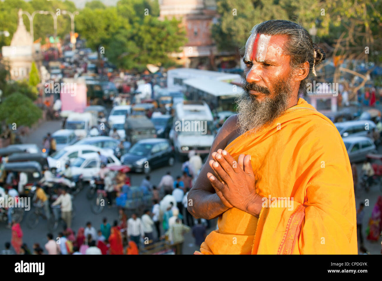 Santo Sadhu meditando in alto al di sopra della congestione del traffico e la vita di strada nella città di Jaipur, Rajasthan, India, Asia Foto Stock