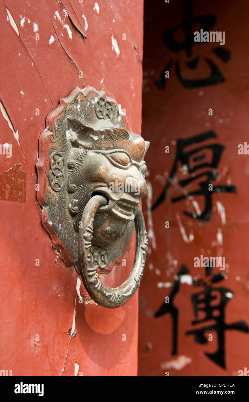 Lion maniglie sagomate sul gate di un hutong di Pechino, Cina Foto Stock