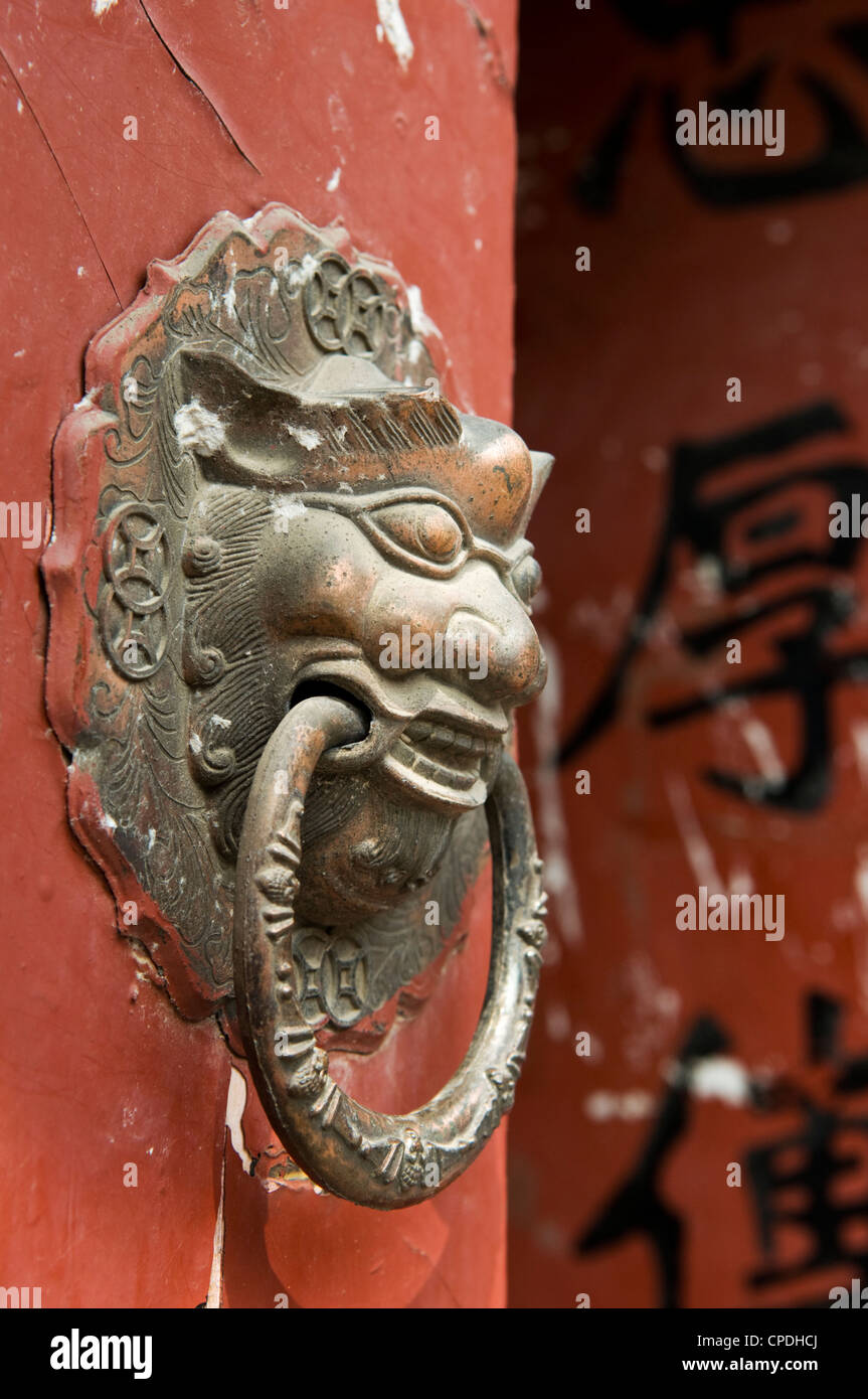 Lion maniglie sagomate sul gate di un hutong di Pechino, Cina Foto Stock