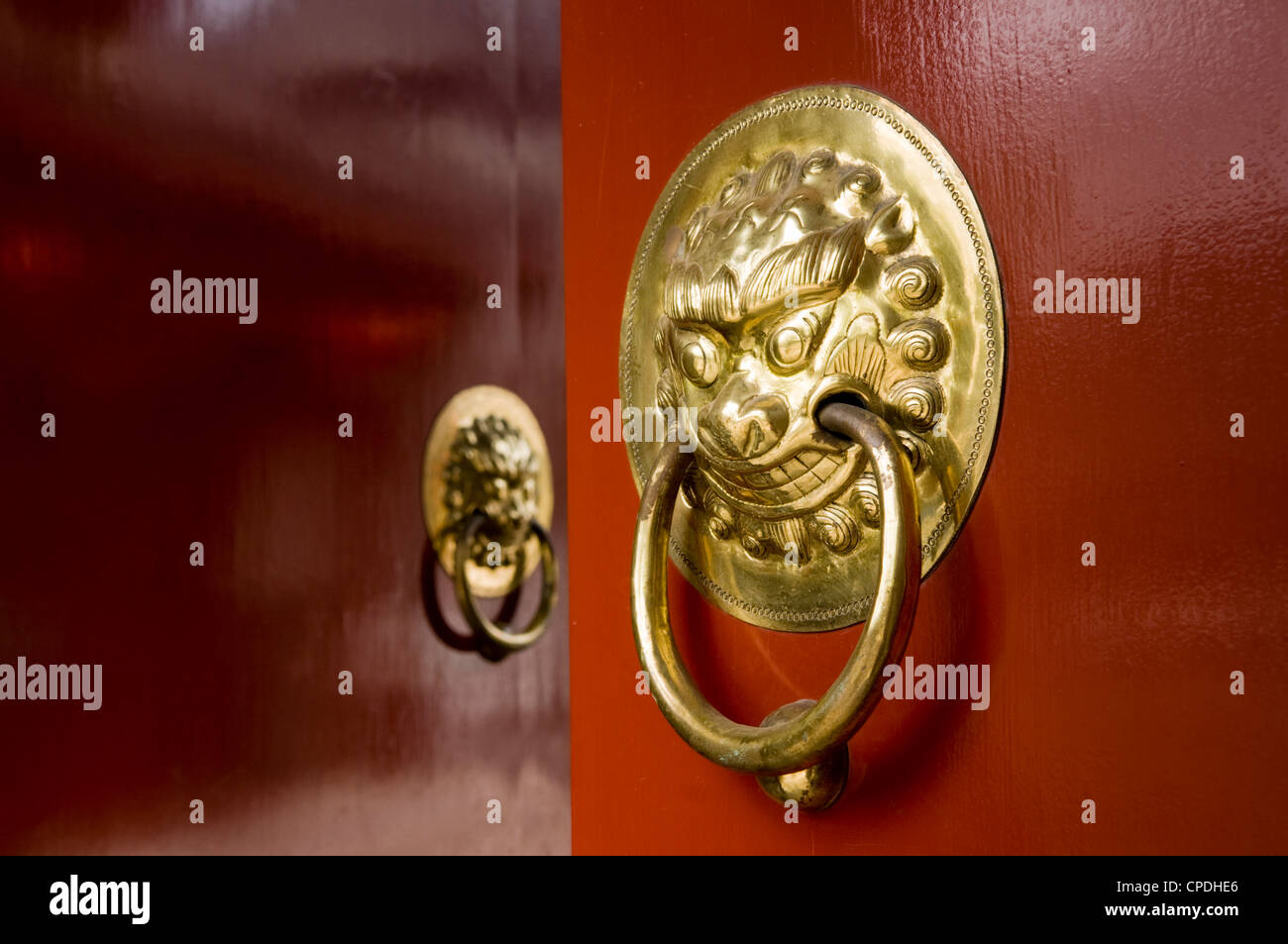 Lion maniglie sagomate sul gate di un hutong di Pechino, Cina Foto Stock