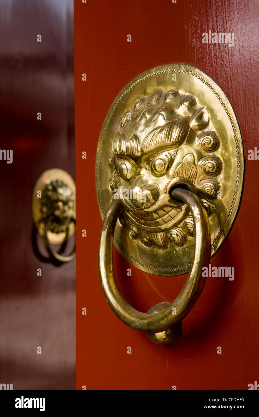 Lion maniglie sagomate sul gate di un hutong di Pechino, Cina Foto Stock
