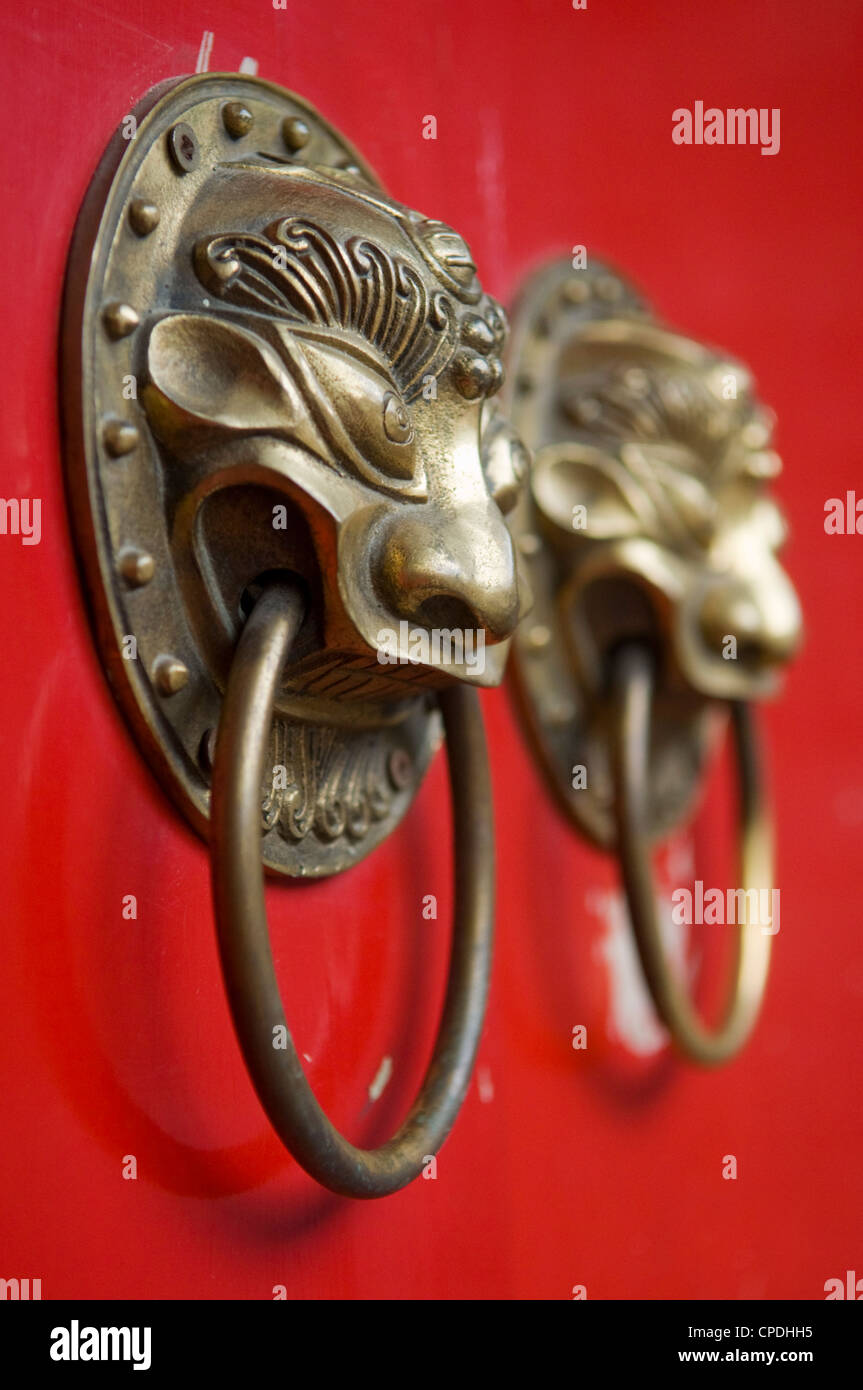 Lion maniglie sagomate sul gate di un hutong di Pechino, Cina Foto Stock